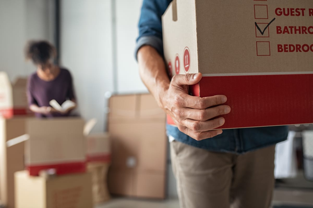 Man carrying boxed items for storage at Your Storage Units