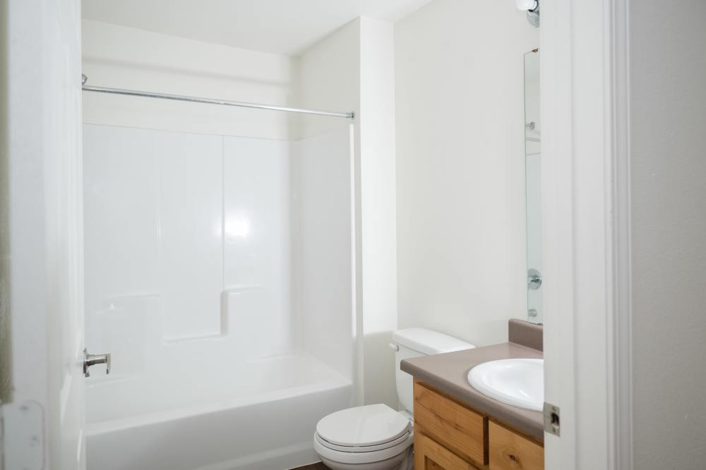 Charming bathroom featuring a sleek tub and modern vanity at Cascade Villas in Wichita Falls, Texas.