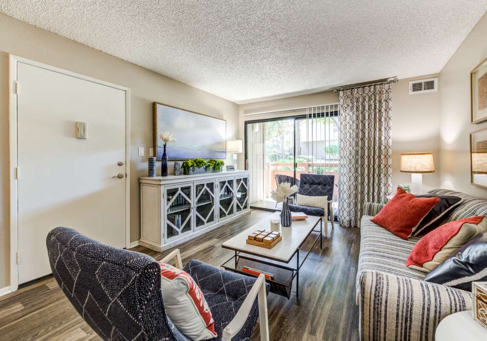 Spacious living room with large sofa and tv at Parcwood Apartments in Corona, California, 