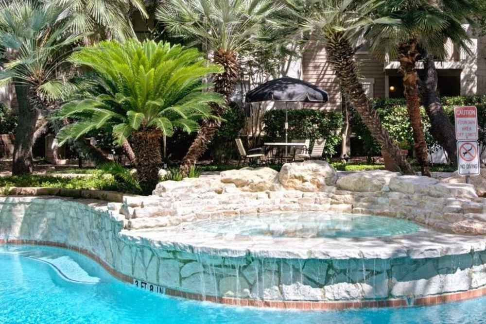 Swimming pool with greenery around at Rock Canyon Apartments in San Antonio, Texas