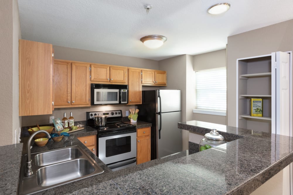 Modern kitchen with quartz countertops and stainless-steel appliances in a model home at Timbers at Tualatin in Tualatin, Oregon