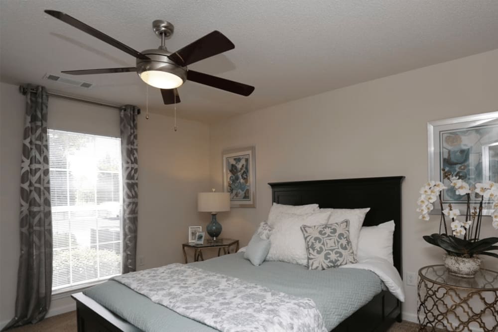 cozy bedroom with a bed a ceiling fan at Arbors at Fairview Apartments in Simpsonville, South Carolina