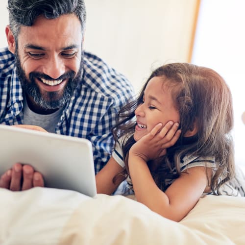 a father and daughter looking at a tablet at Sandpiper Crescent in Virginia Beach, Virginia