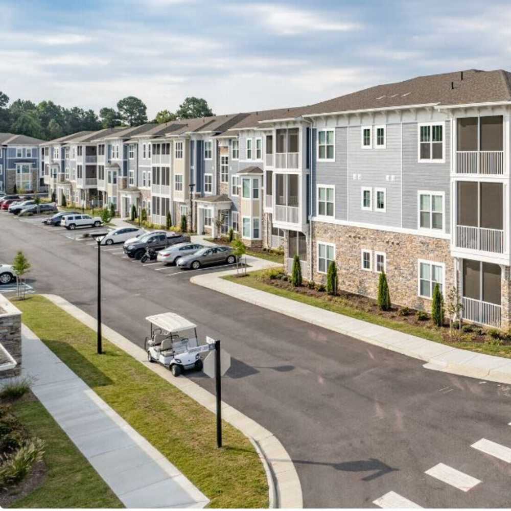 Apartment community with parking and golf cart at The Apartments At Kelton Station in Williamsburg, Virginia