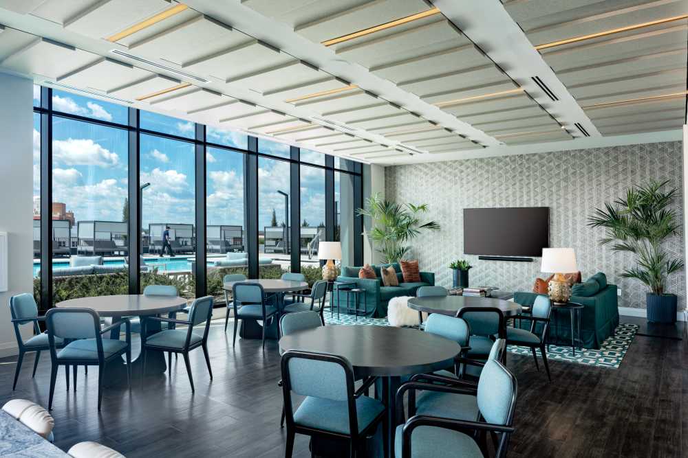 Community lounge area with tall ceilings and ample seating at The Novus Apartments in Durham, North Carolina