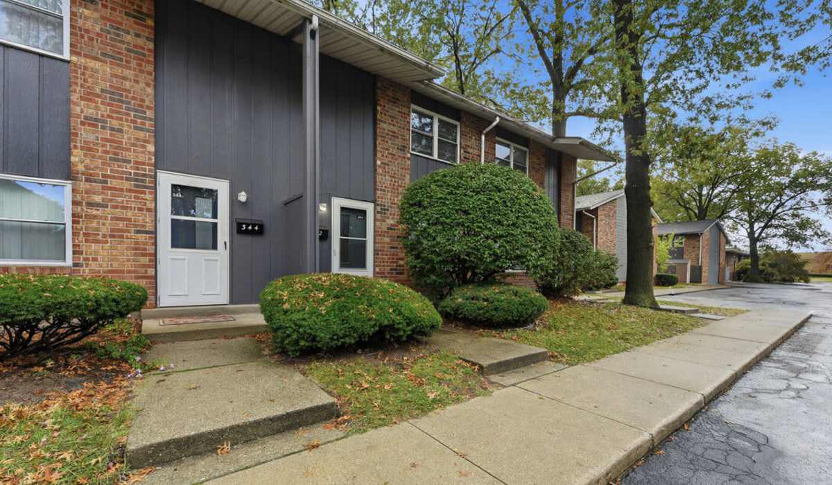 Charming entryway with lush landscaping at The Reserve at Pin Oak Manor Apartments in Mishawaka, Indiana