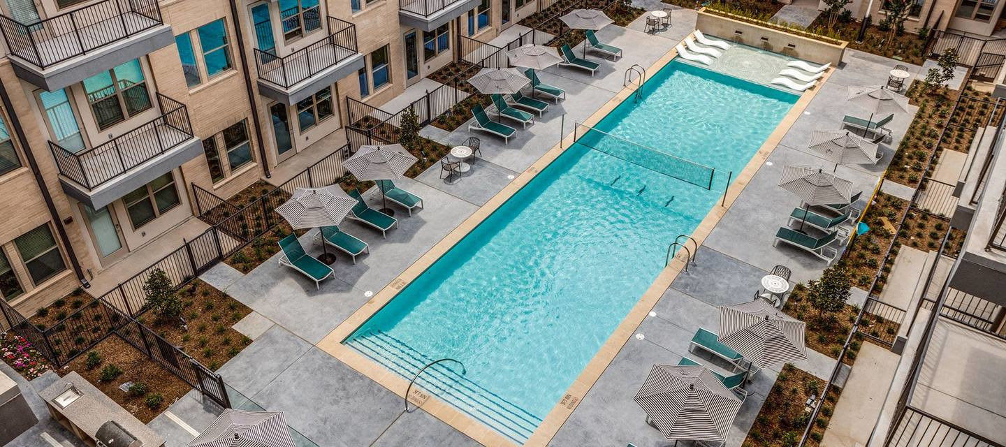 Resort-style pool with lounge chairs and cabanas at Luxia Gallery House, Farmers Branch, Texas