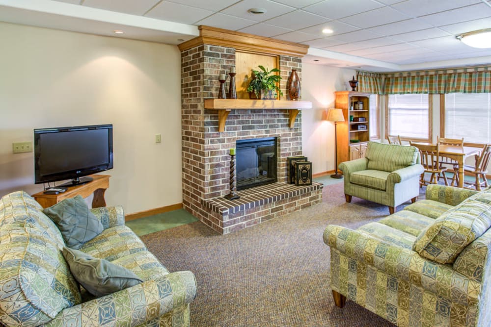 Fireplace lounge and activity room with TV at Addington Place of Carroll in Carroll, Iowa.