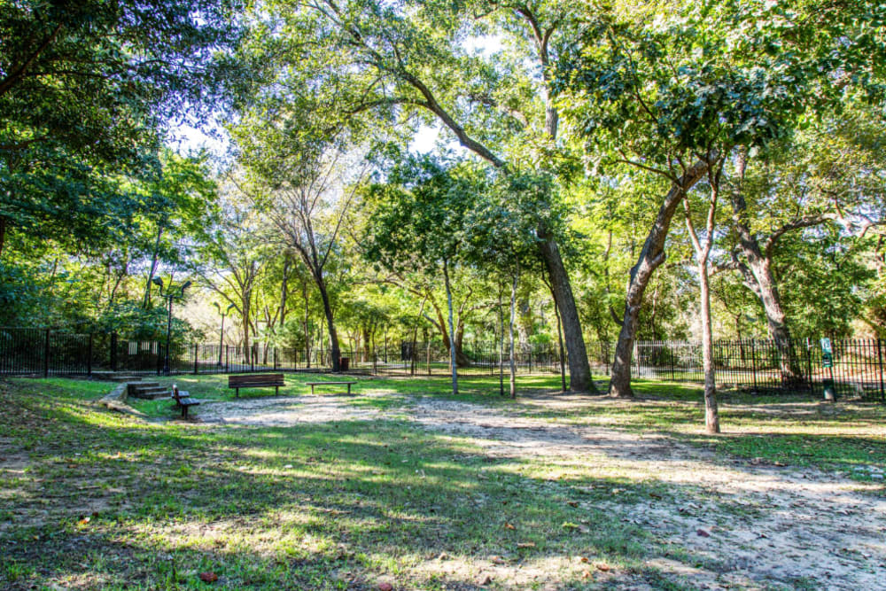 Enclosed dog park with waste station and wood benches at Marquis at Silver Oaks in Grapevine, Texas