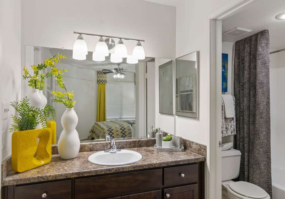 Bright bathroom with large mirror and endant lights at Cabrillo Apartments in Scottsdale, Arizona, 