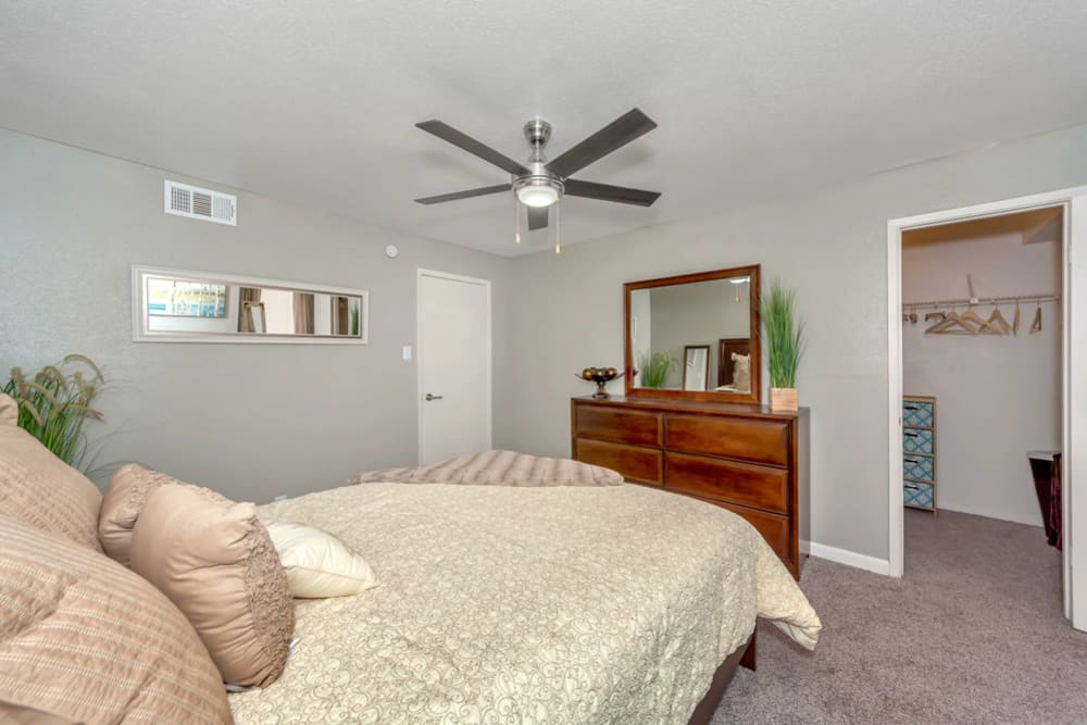 Bright bedroom with plush carpeting and walk-in closet at Rivercrest in Waco, Texas