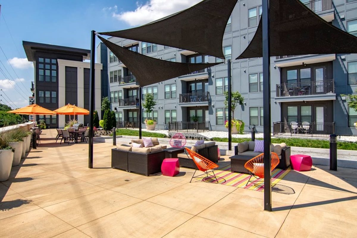 Covered, outdoor couches by the pool at Station R Apartments in Atlanta, Georgia
