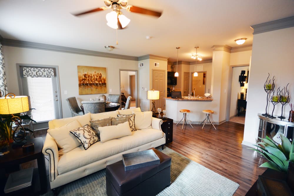 Spacious model living room with luxury plank flooring and a ceiling fan at Estates at McDonough Apartment Homes in McDonough, Georgia