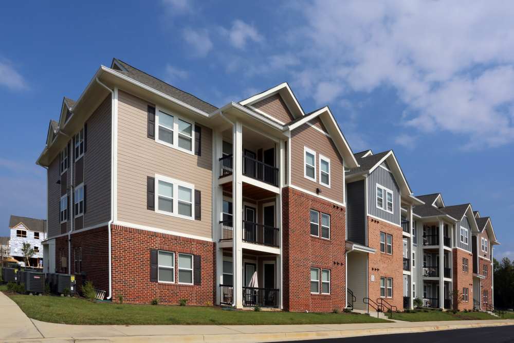 Modern apartment exterior with multiple balconies and brick detailing at Adams Crossing in Waldorf, Maryland