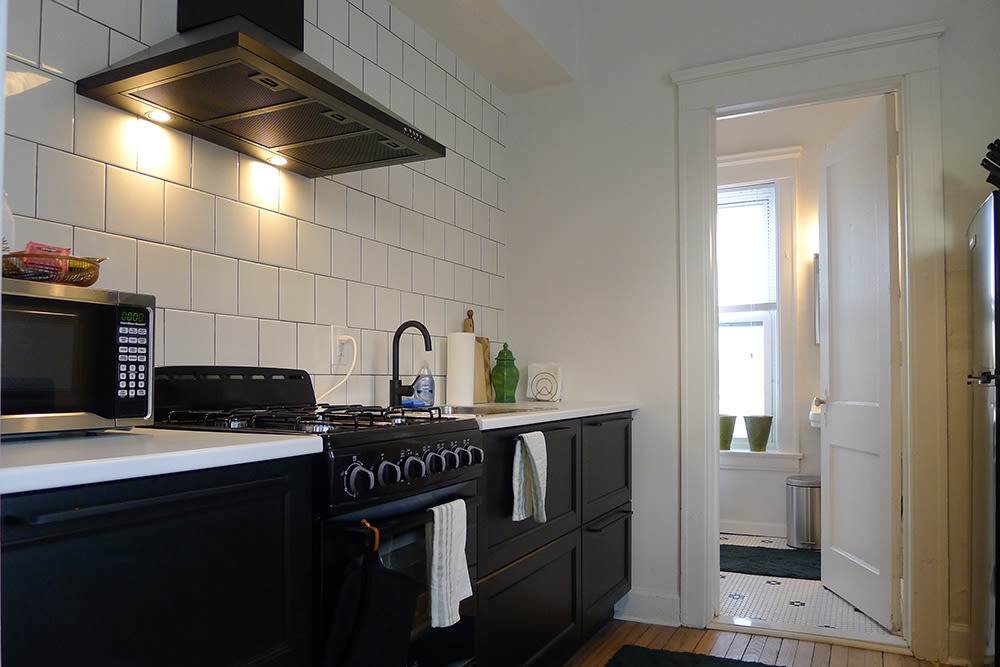 Kitchen with black cabinets at Detroit Living in Detroit, Michigan