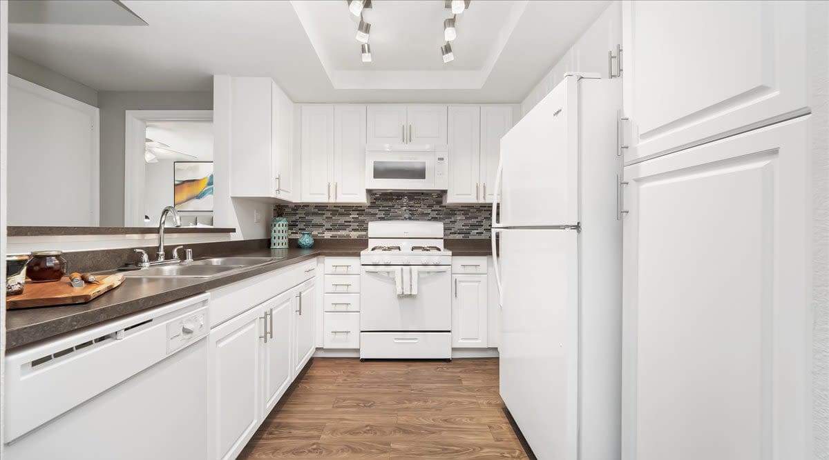 Bright kitchen with white cabinets at  Mirabella Apartments in Bermuda Dunes, California