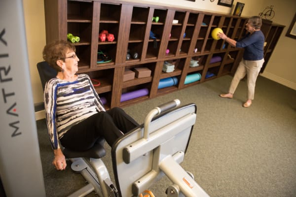 Exercise room with a resident on a leg machine at Deephaven Woods in Deephaven, Minnesota