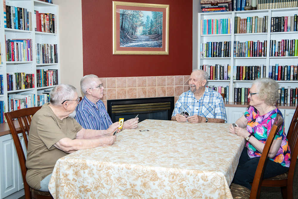 A diverse group seated at a table, collaborating at Peachtree Village Retirement Community in Roswell, New Mexico.
