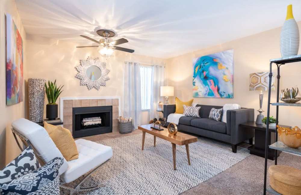 Living room with couch, chair, coffee table, ceiling fan and fireplace at The Pines of Palos Verdes in Mesquite, Texas