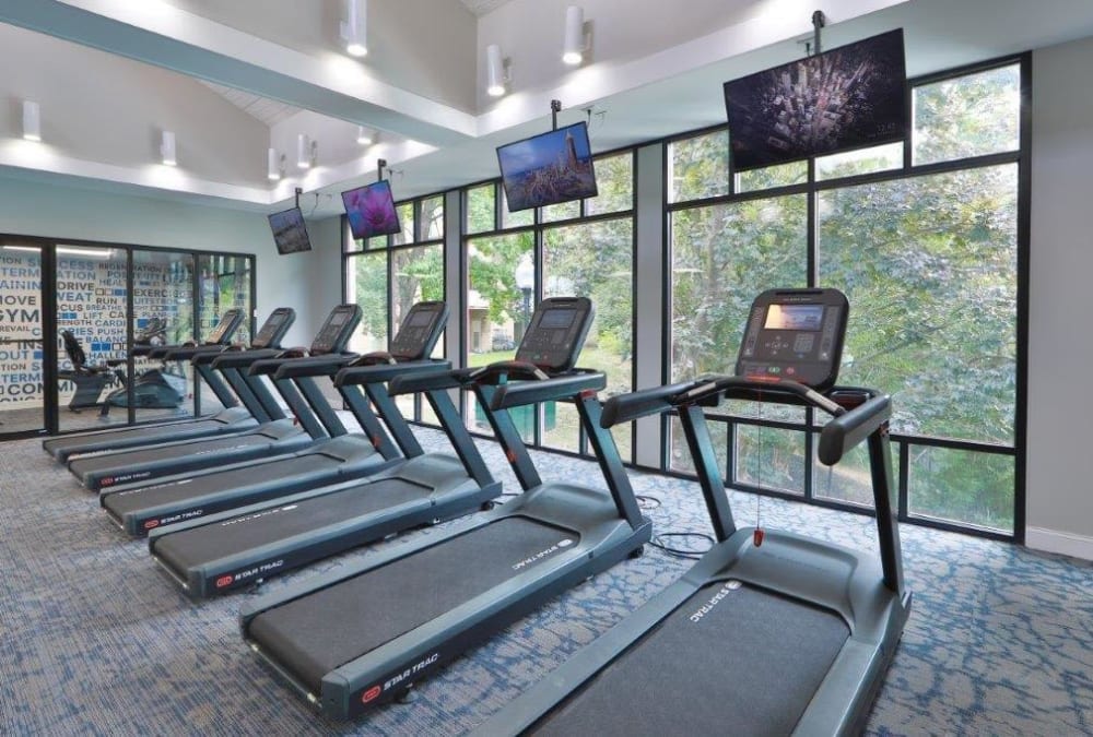 Treadmills and flatscreen TVs in the fitness center at Stoneridge at Mark Center Apartment Homes in Alexandria, Virginia