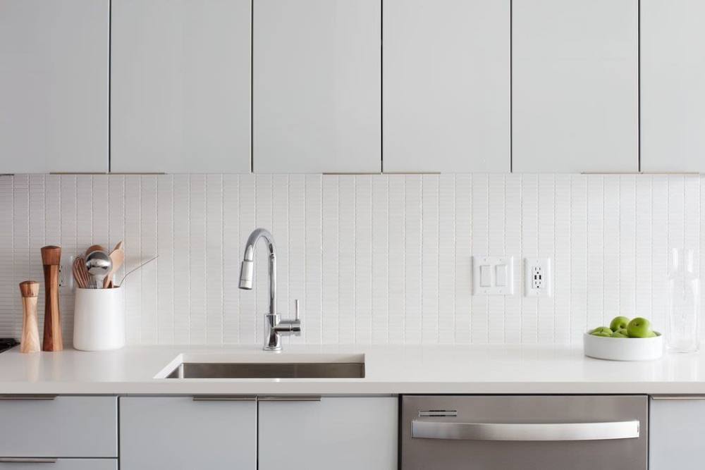 Kitchen island with waterfall faucet and storage units at Ardan in Dallas, Texas