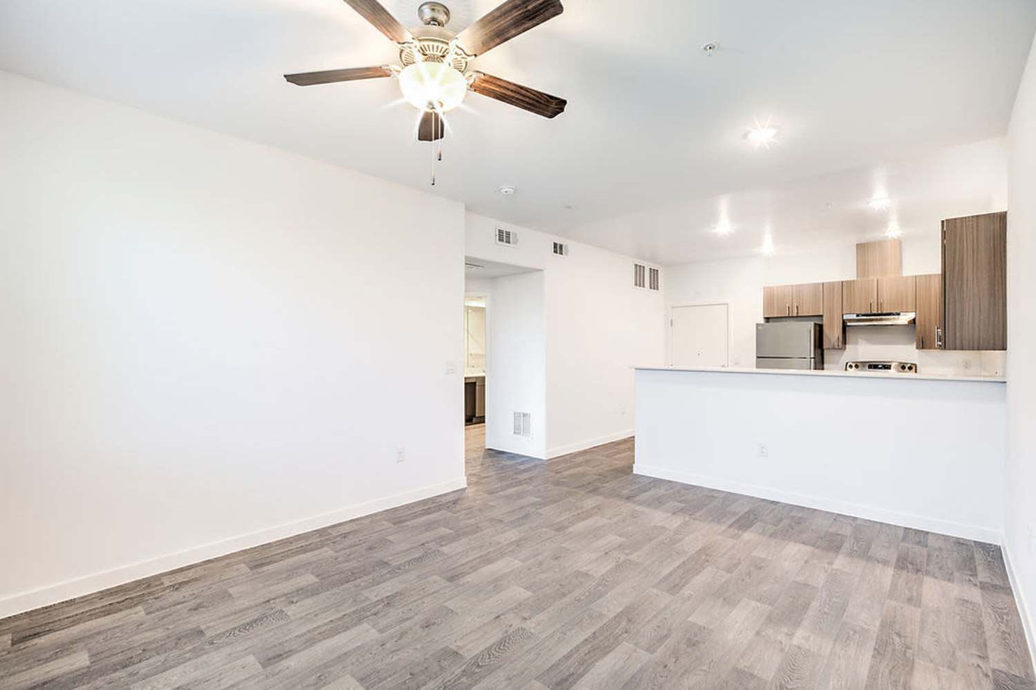 Unfurnished living room with hardwood-style flooring  and kitchen view at Melody in Las Vegas, Nevada
