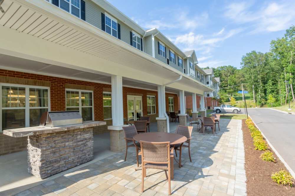 Outside seating area with tables and chairs at The Harmony Collection at Roanoke - Assisted Living in Roanoke, Virginia