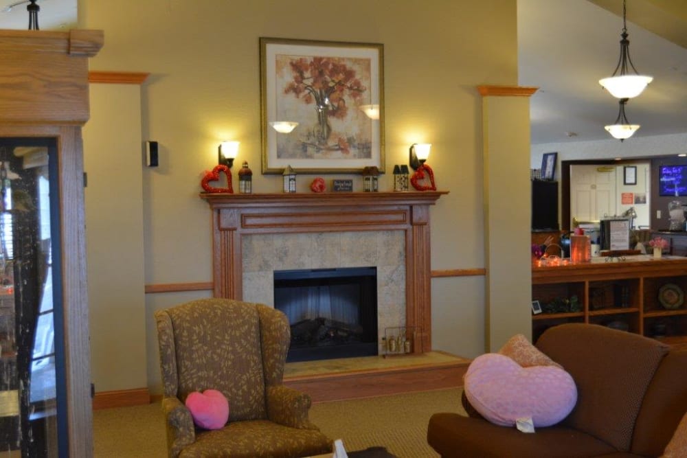 Comfortable chair and sofa near the fireplace at Courtyard Estates at Hawthorne Crossing in Bondurant, Iowa.