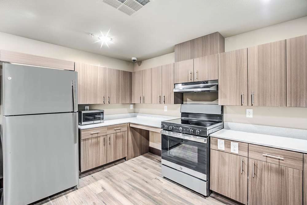 Kitchen with stainless-steel appliances and wooden cabinet at Melody in Las Vegas, Nevada