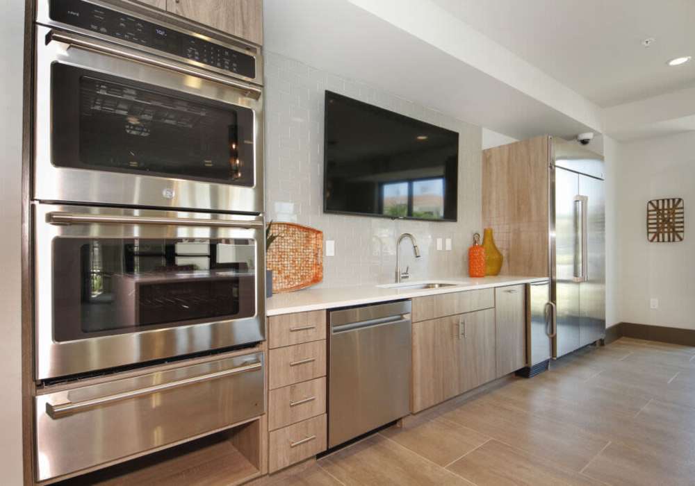 Sleek, modern kitchen with stainless steel appliances and vibrant accents at Messina Luxury Apartments in New Smyrna Beach, Florida