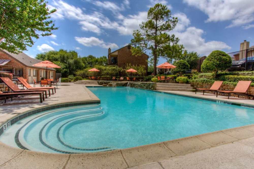 Sparkling swimming pool with lounge chairs at The Pines of Palos Verdes in Mesquite, Texas