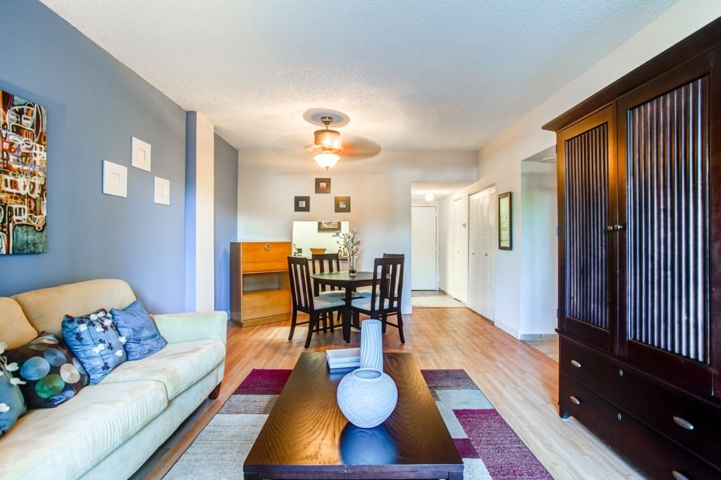 Spacious living area with modern decor in open-concept floor plan of model home at Aliro Apartments in North Miami, Florida