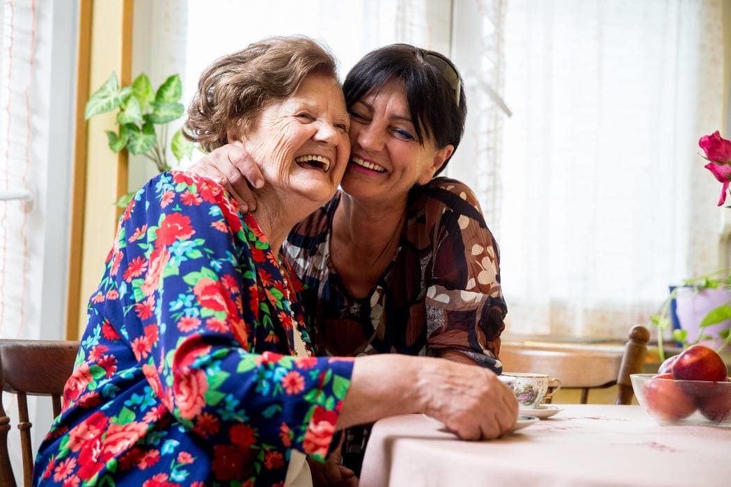 Resident and daughter laughing at Alderbrook Village in Arkansas City, Kansas.