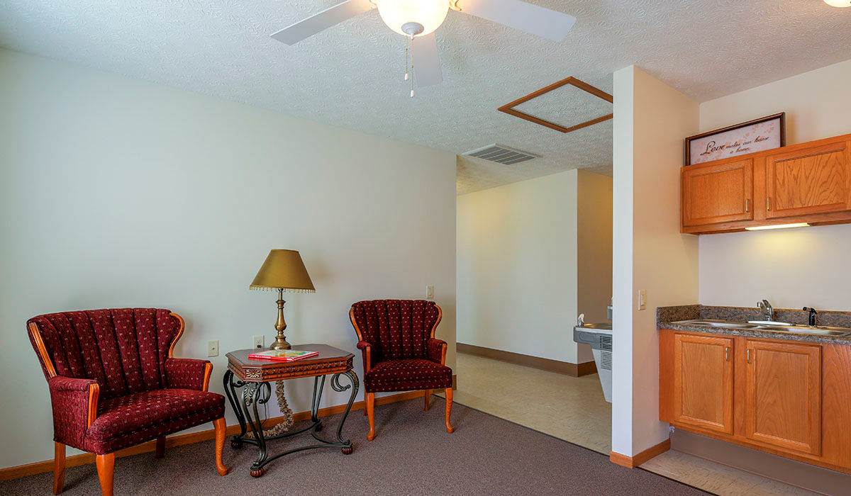 Red upholstered chairs with a lamp and table at Orchard Glen in Orrville, Ohio
