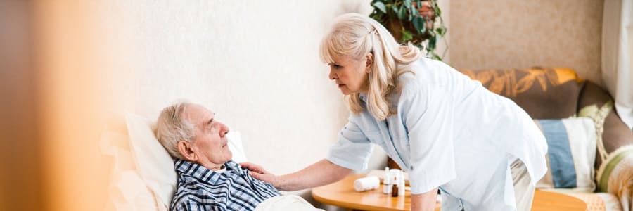 Caretaker comforting a resting resident at a WISH community 