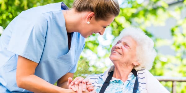 Resident and caretaker smiling at one another outside at Montello Care Center in Montello, Wisconsin