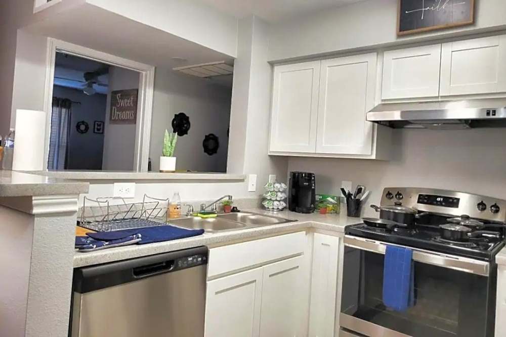 Modern kitchen with white cabinets at Eban Village Apartments in Dallas, Texas