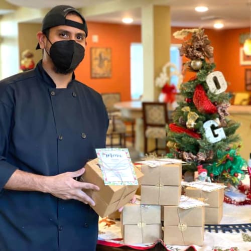 A masked team member setting out presents at The Oxford Grand Assisted Living & Memory Care in McKinney, Texas