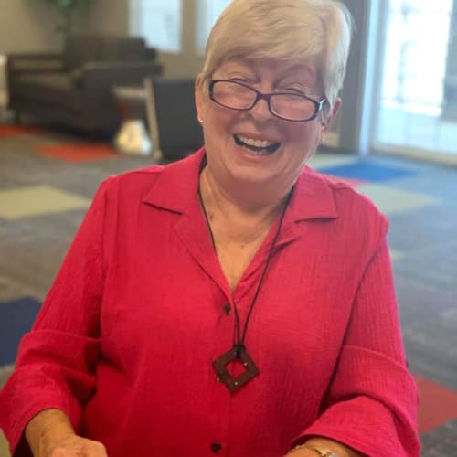 A resident laughing while doing arts & crafts at Oxford Villa Active Senior Apartments in Wichita, Kansas