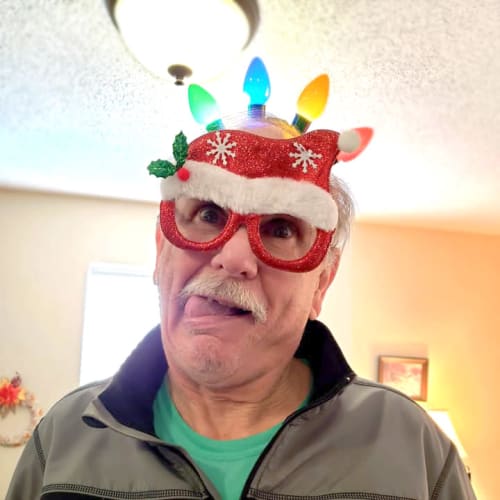 A resident making a goofy face while wearing a light-up cap at Alderbrook Village in Arkansas City, Kansas