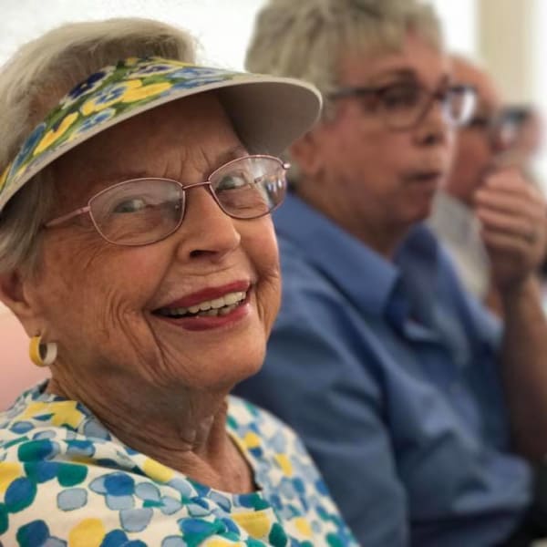 Resident in a sun visor smiling at the camera at Quail Park on Cypress in Visalia, California
