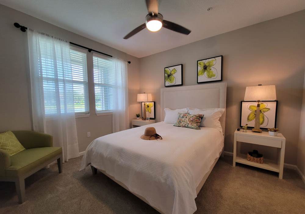 Cozy bedroom with elegant decor and natural light at Messina Luxury Apartments in New Smyrna Beach, Florida