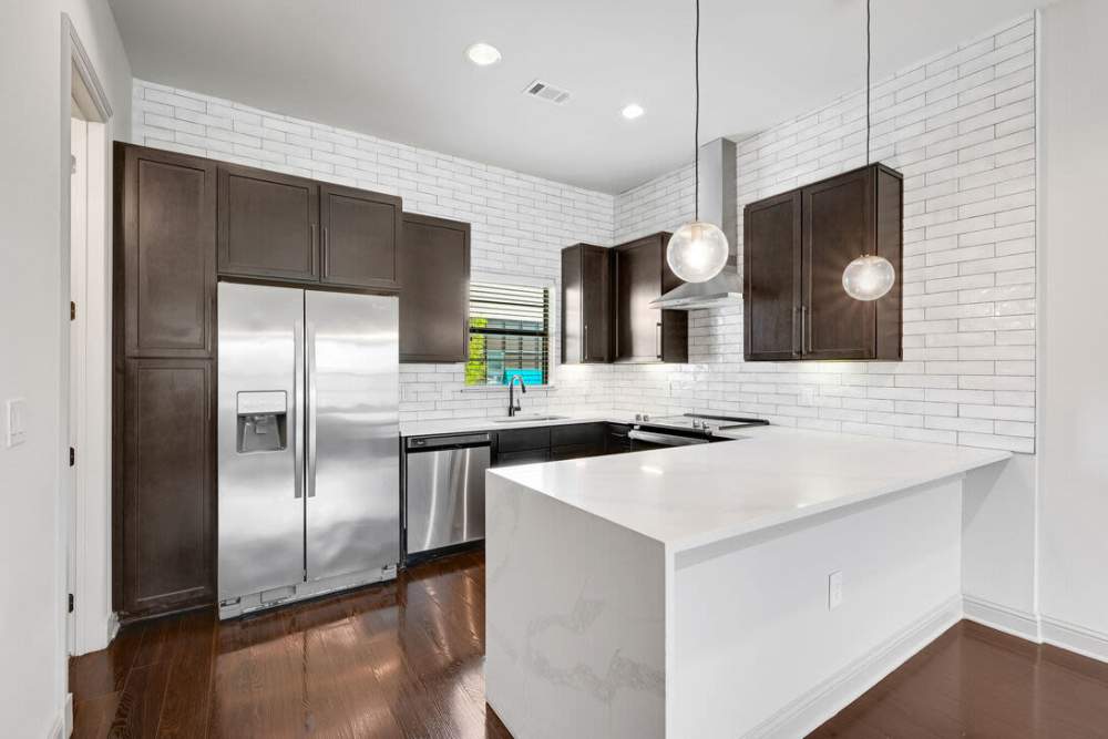 Kitchen with flat countertop and side by side refrigerator at Domain Memorial in Houston, Texas