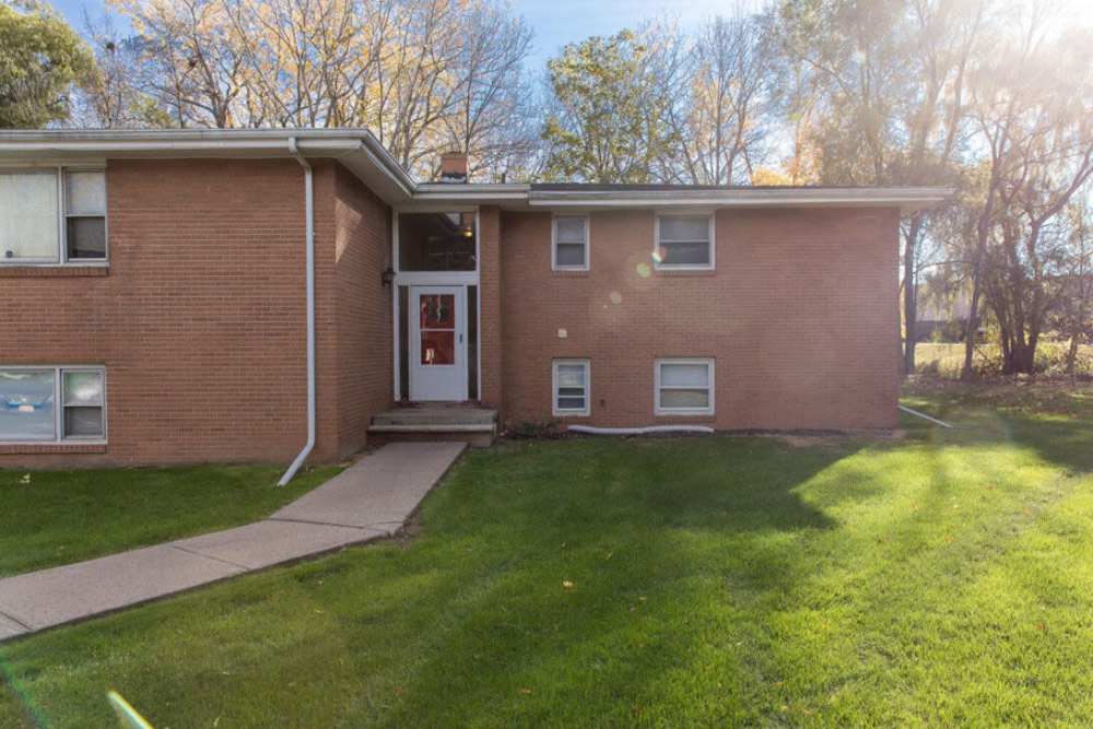 Gated entrance with green lawn and trees at 4500 Dewey Ave Apartments in Rochester, New York
