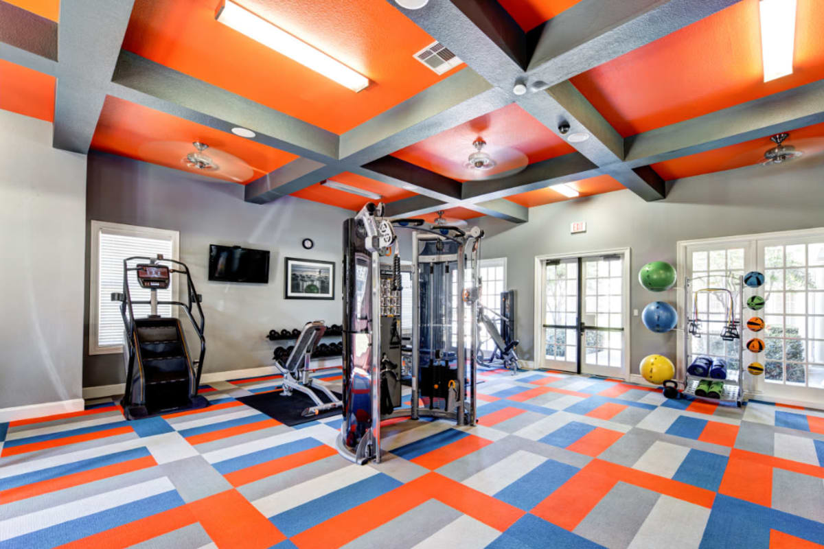 Fitness room with weight machine, stair climber, and medicine balls on rack at Marquis at Silver Oaks in Grapevine, Texas
