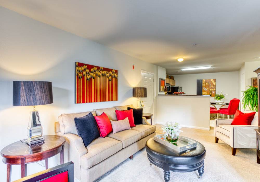 Brightly lit living room with connecting kitchen bar, and room for a couch, side table coffee table, and chair at Eagle Point Village in Fayetteville, North Carolina 