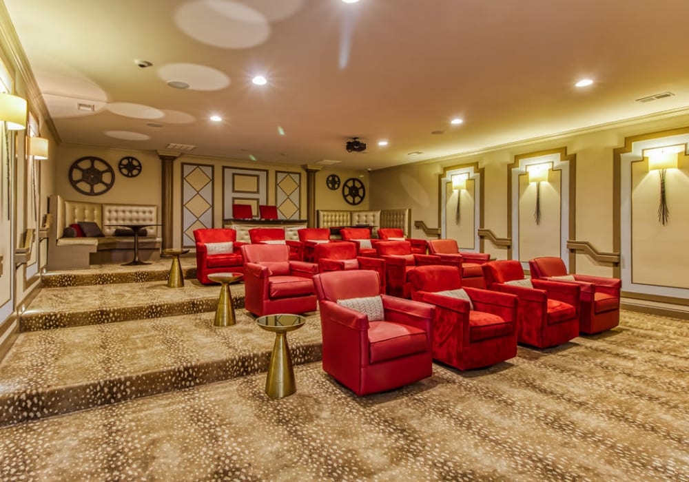 Indoor community movie theater with three rows of red chairs and a couch at Everwood at The Avenue in Murfreesboro, Tennessee