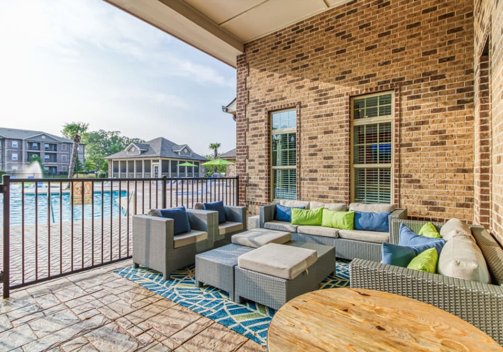 Patio with comfortable couch seating and connects to sparkling swimming pool at Everwood at The Avenue in Murfreesboro, Tennessee