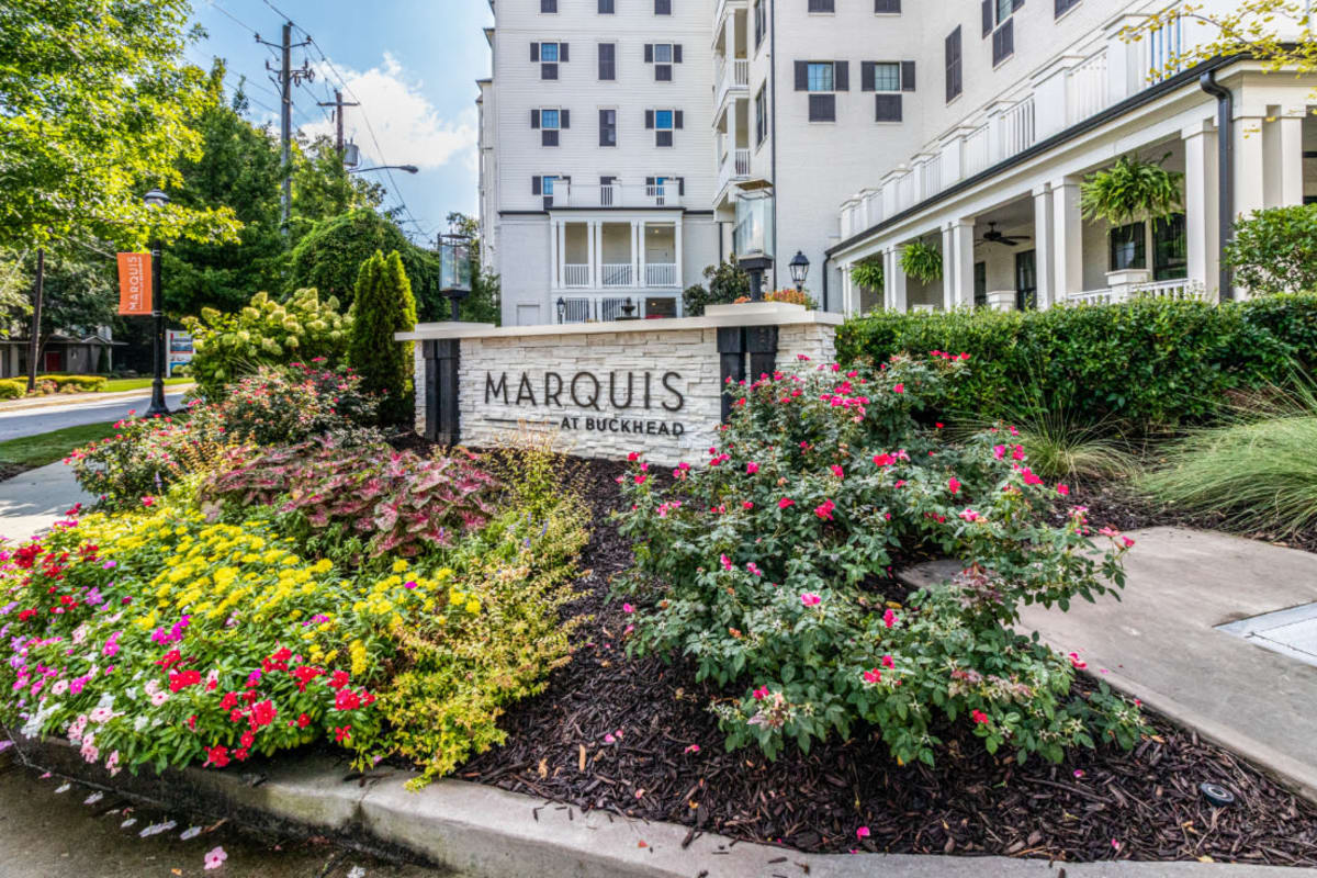 Property sign surrounded by a variety of flowers and plants at Marquis at Buckhead in Atlanta, Georgia