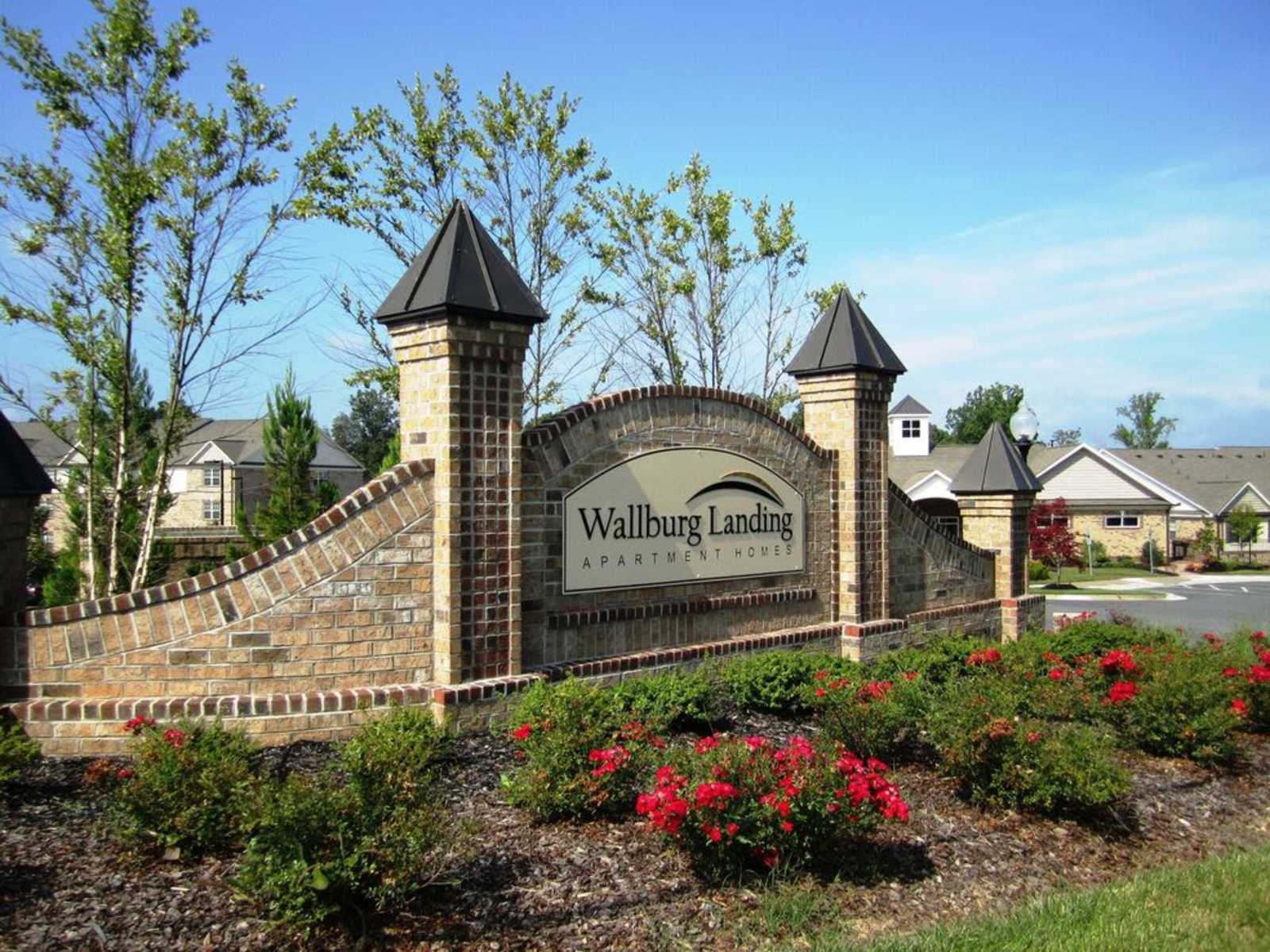 Gate with sign at main entry of Wallburg Landing Apartment Homes